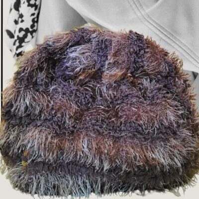 Bolso de mano con textura de pelo largo muy suave en tonos marrón oscuro y puntas grisáceas.